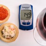 Mujer bebiendo agua mientras consulta un gráfico de glucosa en sangre.