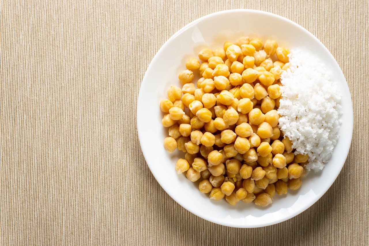 Texto que muestra una variedad de legumbres en un plato colorido, representando una dieta saludable.